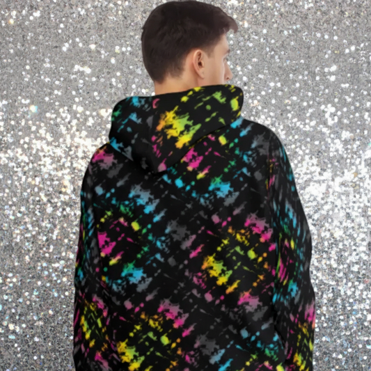 Man from the head down to the waist, posing standing facing away in a nightclub bar wearing a 100% cotton vibrant Minstrel Magic tie-dye all-over print hoodie. The hoodie is black with splashes of bright pink, orange yellow, green, blue and grey. It is a bold fun design for everyday wear.