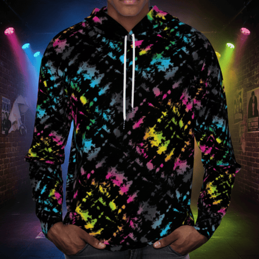 Man from the chin down to the waist, posing standing facing forwards wearing a 100% cotton vibrant Minstrel Magic tie-dye all-over print hoodie. He is standing outside at a public festival market. The hoodie is black with splashes of bright pink, orange yellow, green, blue and grey. It is a bold fun design for everyday wear.