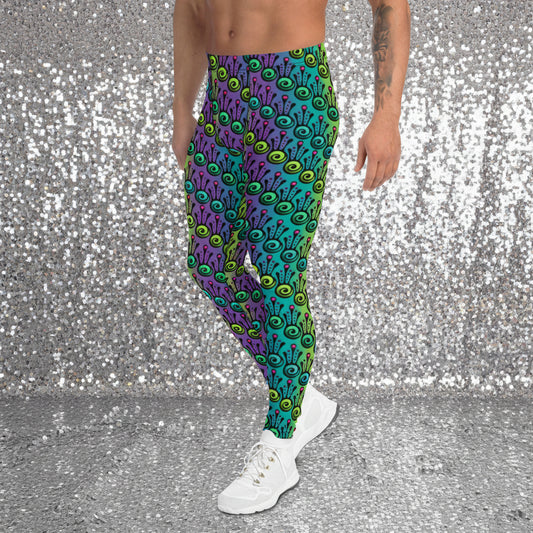 Man from the waist down wearing men's jungle tribal frog funky festival yoga leggings standing facing to the left with his hands by his sides. He is wearing white trainers and is standing on a nightclub dance floor with colourful green, pink and purple lights in the background. The jungle tribal frog pattern is an abstract pattern with a blended green and purple background.
