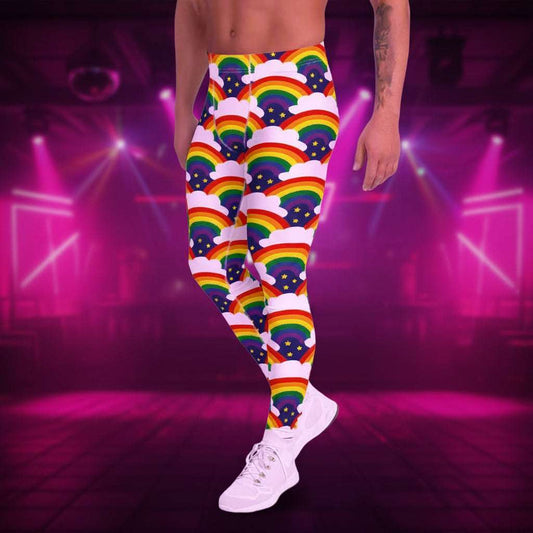Man from the waist down wearing men's Rainbow Sparkle funky festival yoga leggings standing facing to the left with his hands by his sides. The man is standing in a nightclub with colourful pink lighting and other club goers in the background. The rainbow sparkle pattern features repeating rainbows and white fluffy clouds with three small yellow stars beneath each rainbow. The background colour is navy blue