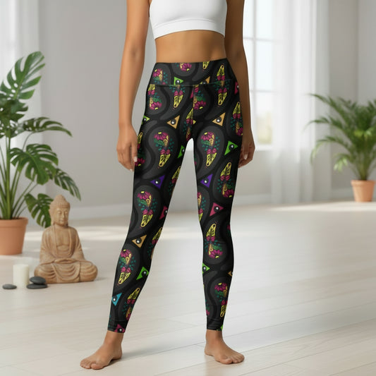 High waist Black Paisley Party festival yoga leggings front view. Woman is standing in a boho interior room. The Paisley Party design is a bold colourful rainbow geometric print pattern. Designed in Wales, UK | Sassy Seagull.