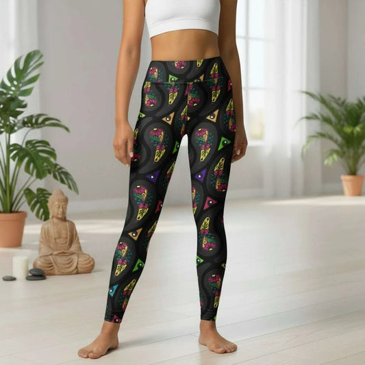 High waist Black Paisley Party festival yoga leggings front view. Woman is standing in a boho interior room. The Paisley Party design is a bold colourful rainbow geometric print pattern. Designed in Wales, UK | Sassy Seagull.