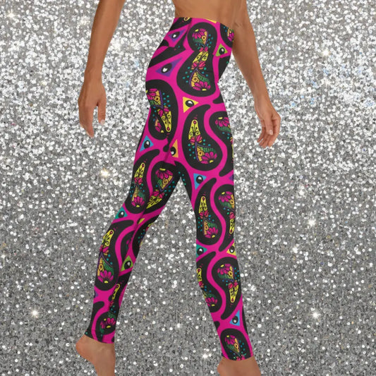 High waist Pink Paisley Party festival yoga leggings side view. Woman is standing in front of a shimmery silver sequin backdrop. The Paisley Party design is a bold colourful rainbow geometric print pattern. Designed in Wales, UK | Sassy Seagull.