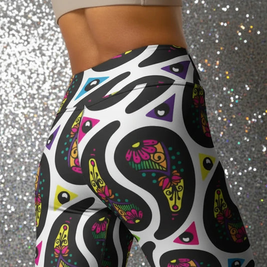 High waist White Paisley Party festival yoga leggings close up back view. Woman is standing in a boho interior room. The Paisley Party design is a bold colourful rainbow geometric print pattern. Designed in Wales, UK | Sassy Seagull.