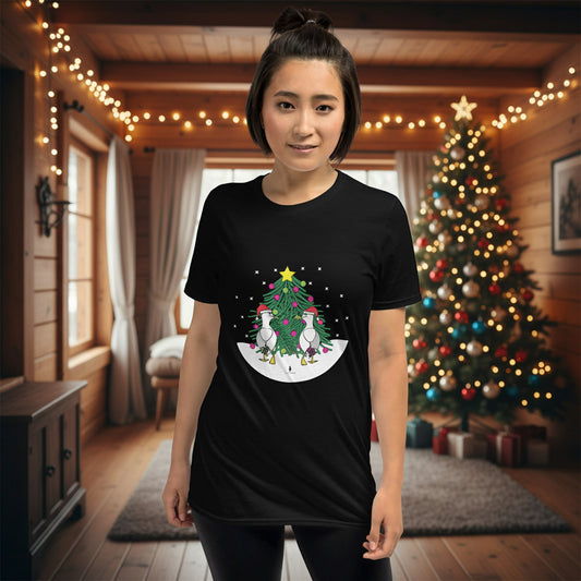 Person wearing a black 100% cotton Christmas t-shirt with two sassy seagulls in front of a decorated Christmas tree. The person is standing in a wooden chalet decorated for Christmas.