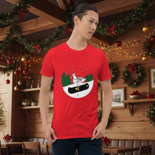 Man wearing a red 100% cotton snowboarding seagull Christmas t-shirt, in a rustic cafe filled with red, green and gold Christmas decorations