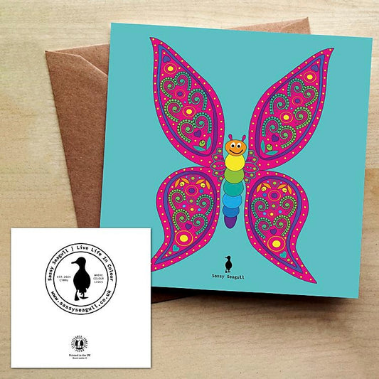 Colorful butterfly greeting card with a brown envelope on a wooden surface.