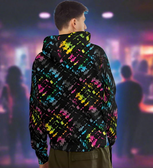 Man from the head down to the waist, posing standing facing away in a nightclub bar wearing a 100% cotton vibrant Minstrel Magic tie-dye all-over print hoodie.  The hoodie is black with splashes of bright pink, orange yellow, green, blue and grey. It is a bold fun design for everyday wear.