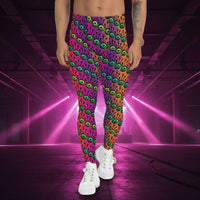 Man from the waist down wearing men's fire tribal frog funky festival yoga leggings standing facing forwards with his hands by his sides. He is wearing white trainers and is standing in a grassy park with trees and other walkers in the background. The fire tribal frog pattern  is a funky abstract pattern with a blended pink, purple and orange background.