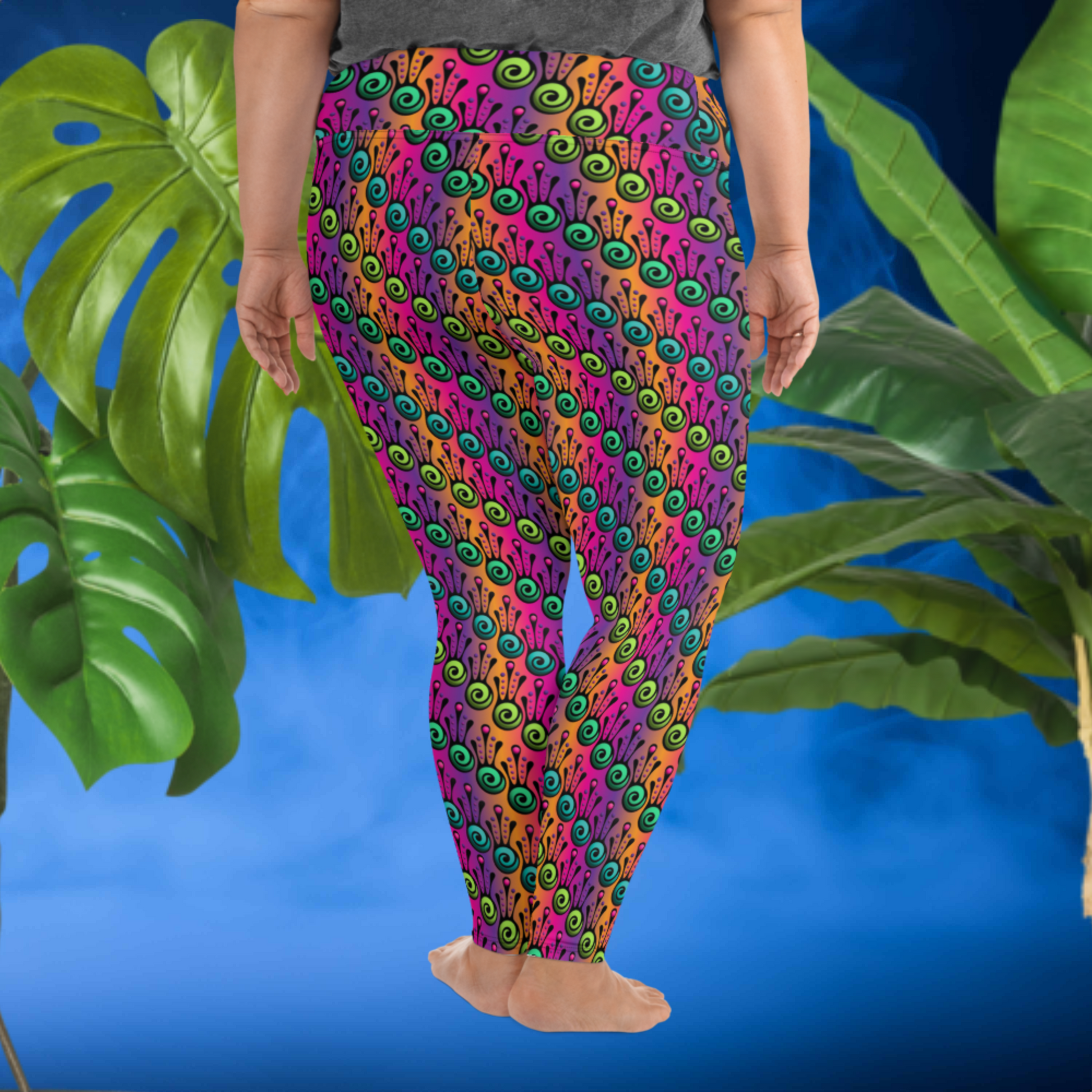 A curvy woman from the waist down wearing plus-size high-waist Tribal Frog funky festival yoga leggings standing facing to the back with both of her hands by her sides. The woman is standing in front of a smoky blue background in front of two large leafy plants. The fire tribal frog pattern is an abstract pattern with a blended purple, pink and orange background.