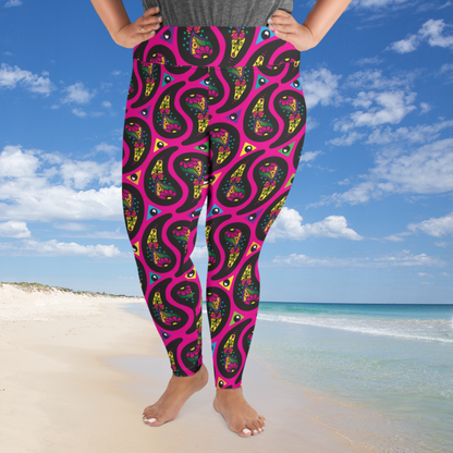 A curvy woman from the waist down wearing plus-size hot pink Paisley Party high-waist funky festival yoga leggings standing facing to the front with her hands on her hips. The woman is standing on a white sandy beach with blue sea in the distance to the right on the horizon and a blue sky filled with white fluffy clouds.The Paisley Party pattern is a repeating paisley pattern. The paisley shapes are filled with decorative detail in a variety of bright colours against a hot pink background.
