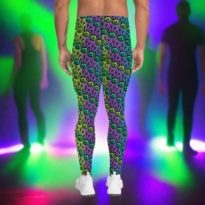 Man from the waist down wearing men's jungle tribal frog funky festival yoga leggings standing facing away with his hands by his sides. He is wearing white trainers and is standing on a nightclub dance floor with other people in the background and surrounded by green, purple and pink lighting. The jungle tribal frog pattern  is an abstract pattern with a blended green and purple background.
