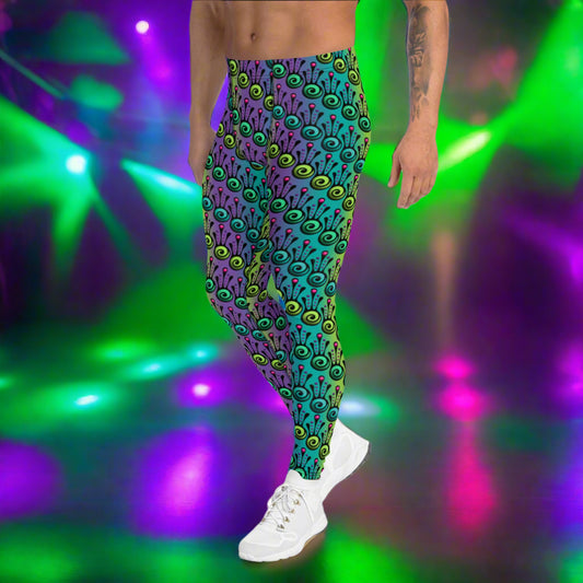 Man from the waist down wearing men's jungle tribal frog funky festival yoga leggings standing facing to the left with his hands by his sides. He is wearing white trainers and is standing on a nightclub dance floor with colourful green, pink and purple lights in the background. The jungle tribal frog pattern  is an abstract pattern with a blended green and purple background.