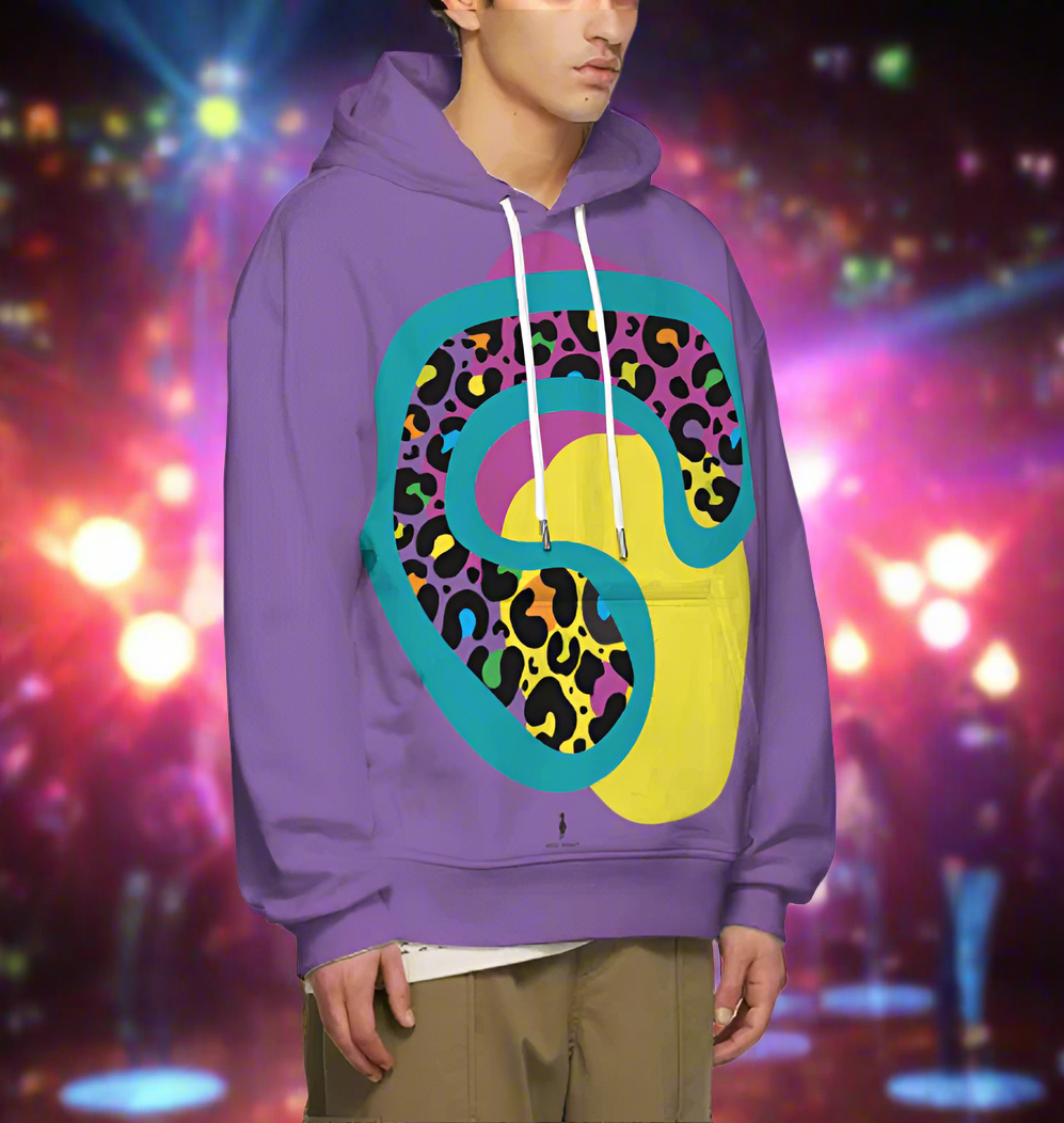 Man from the chin down to the thighs, posing standing facing to the right wearing a 100% cotton vibrant purple leopard leopard splodge graphic hoodie. He is standing against a backdrop of coloured lights in a nightclub setting. The hoodie is purple with a retro rainbow coloured leopard print design covering the front. A large turquoise-green leopard print motif contains lots of smaller leopard print motifs with rainbow coloured centres. This lies on top of large pink and yellow 