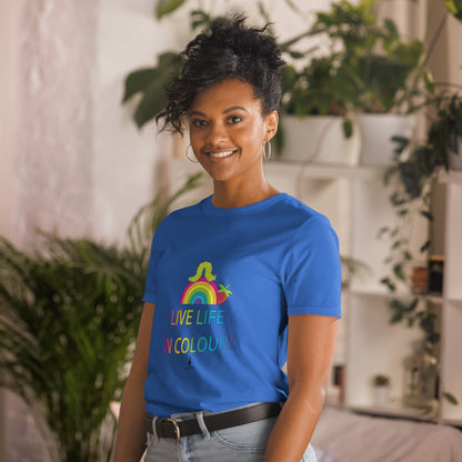 Woman wearing a royal blue 100% cotton vibrant, rainbow live life in colour t-shirt in a bohemian interior decorated with plants.