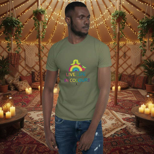 Man wearing a khaki green 100% cotton vibrant, rainbow live life in colour t-shirt in a bohemian yurt interior decorated with fairy lights, rugs, candles and plants.