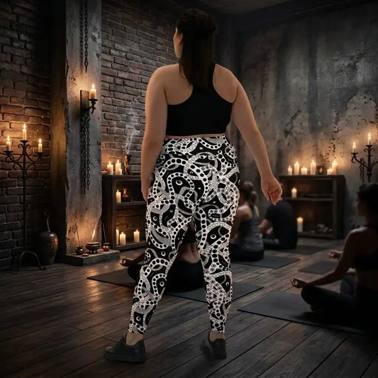 Plus size women's high waist black and white yoga festival leggings back view. Woman is standing in a heavy metal yoga studio.  The Who's Afraid Of The Dark design is a bold abstract pattern. Designed in Wales, UK | Sassy Seagull. 