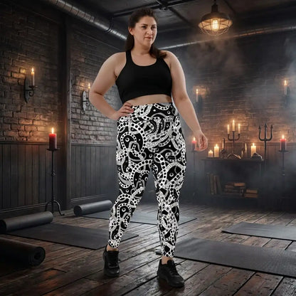 Plus size women's high waist black and white yoga festival leggings front view. Woman is standing in a heavy metal yoga studio.  The Who's Afraid Of The Dark design is a bold abstract pattern. Designed in Wales, UK | Sassy Seagull. 
