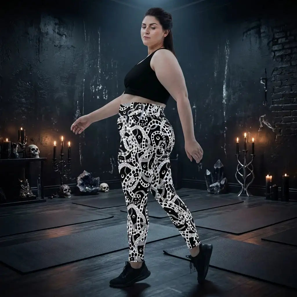Plus size women's high waist black and white yoga festival leggings side view. Woman is posing in a heavy metal yoga studio.  The Who's Afraid Of The Dark design is a bold abstract pattern. Designed in Wales, UK | Sassy Seagull. 