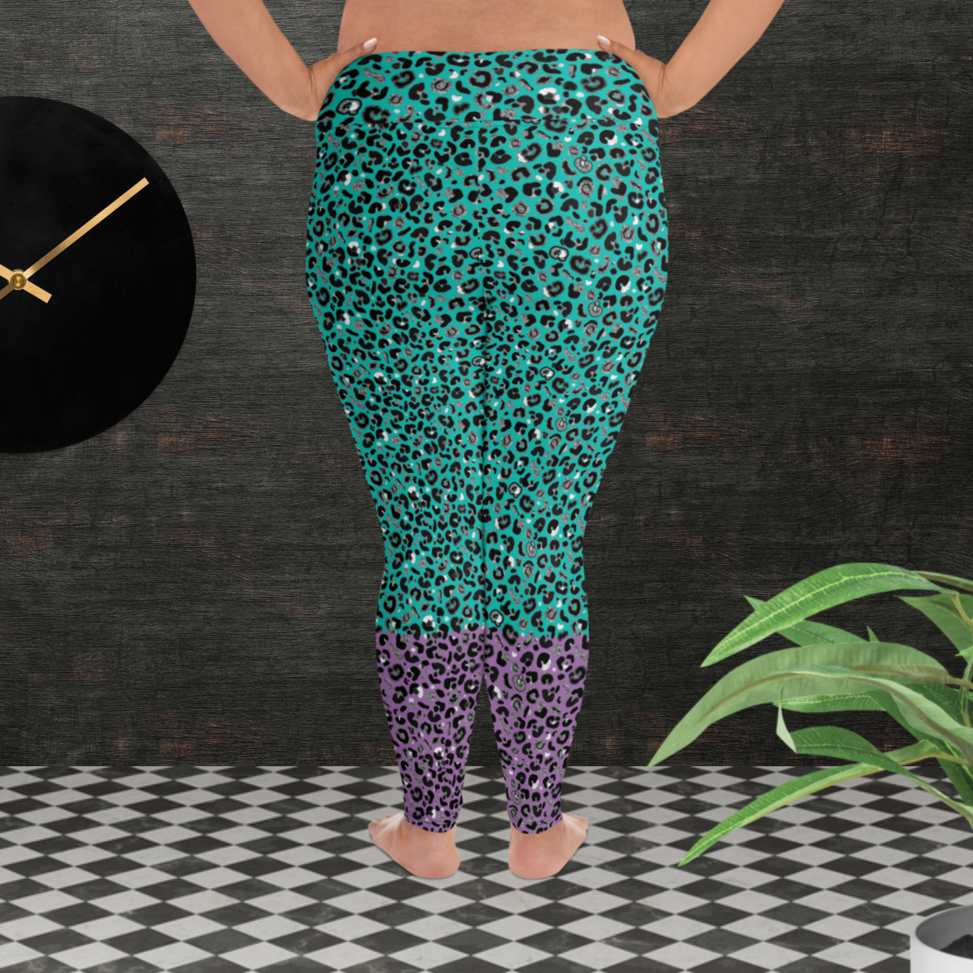 A curvy woman from the waist down wearing plus-size high-waist Purple and Green Leopard Glamour funky festival yoga leggings standing facing backwards. The woman is standing in front of a textured grey background with a black and gold wall clock to the left and a partially visible leafy plant on the floor in the bottom right.  This design features an animal print pattern in black, grey and white, printed at a medium scale. The top 3/4 background is mint green with the bottom 1/4 purple