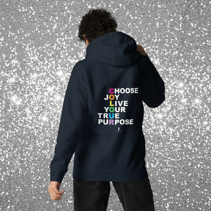 Woman facing away wearing a navy hoodie with 'Choose Joy. Live Your True Purpose' on the back. She is standing in a cosy boho cafe filled with plants and wooden tables.