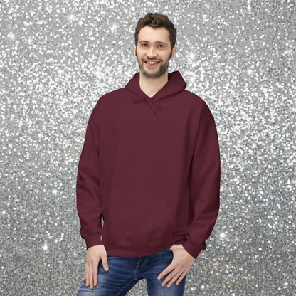Man facing forward wearing a maroon hoodie with a plain front. He is standing in a cosy boho cafe filled with plants and wooden tables.