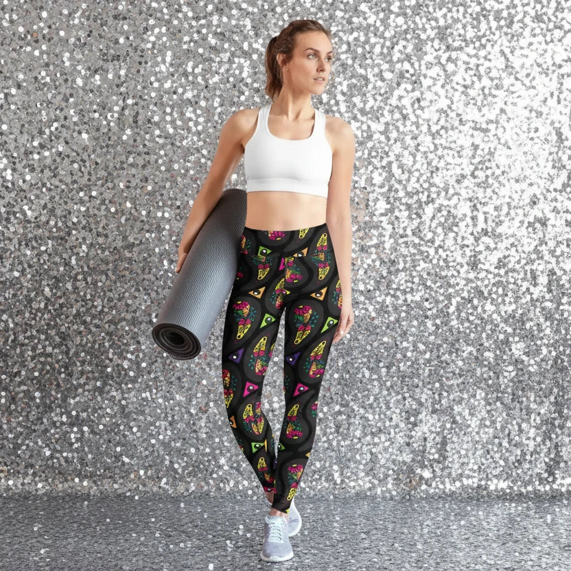 High waist Black Paisley Party festival yoga leggings lifestyle view. Woman is standing in an interior setting.  The Paisley Party design is a bold colourful rainbow geometric print pattern. Designed in Wales, UK | Sassy Seagull. 