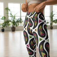 High waist White Paisley Party festival yoga leggings close up front view. Woman is standing in a boho interior room.  The Paisley Party design is a bold colourful rainbow geometric print pattern. Designed in Wales, UK | Sassy Seagull. 
