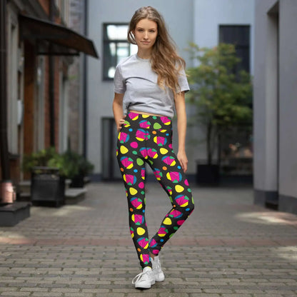 High waist Funk Party Original festival yoga leggings lifestyle view. The woman is standing in a an outdoor old-town setting.  The Funk Party design is a bold colourful abstract print. Designed in Wales, UK | Sassy Seagull. 