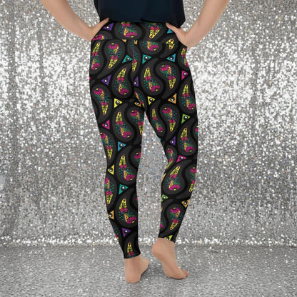 High waist Plus Size Black Paisley Party festival yoga leggings back view. Woman is standing in a boho interior room.  The Paisley Party design is a bold colourful rainbow geometric print pattern. Designed in Wales, UK | Sassy Seagull. 