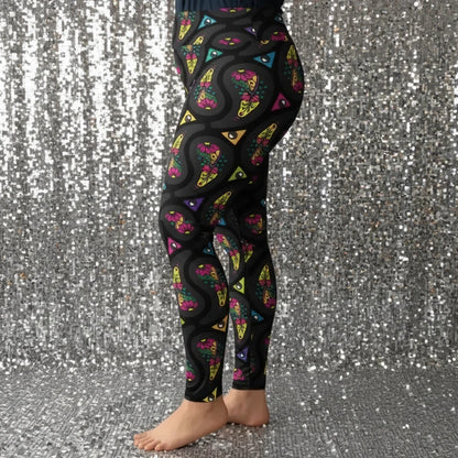 High waist Plus Size Black Paisley Party festival yoga leggings left side view. Woman is standing in a boho interior room.  The Paisley Party design is a bold colourful rainbow geometric print pattern. Designed in Wales, UK | Sassy Seagull. 