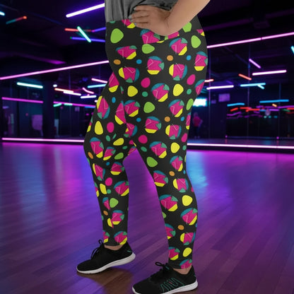 Plus-size high waist Funk Party Original festival yoga leggings side view. The woman is standing in a rustic boho setting with plants, fairy lights and bunting in the background.  The Funk Party design is a bold colourful abstract print. Designed in Wales, UK | Sassy Seagull. 