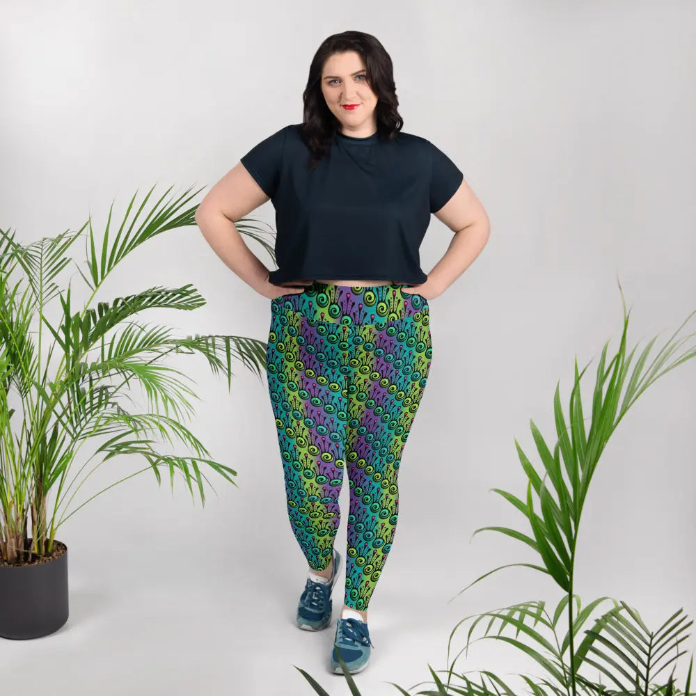 High waist Plus-Size Jungle Tribal Frog festival yoga leggings lifestyle view. Woman is standing in a boho interior room.  The Tribal Frog design is a bold colourful abstract print on a blended green, purple and blue background. Designed in Wales, UK | Sassy Seagull. 