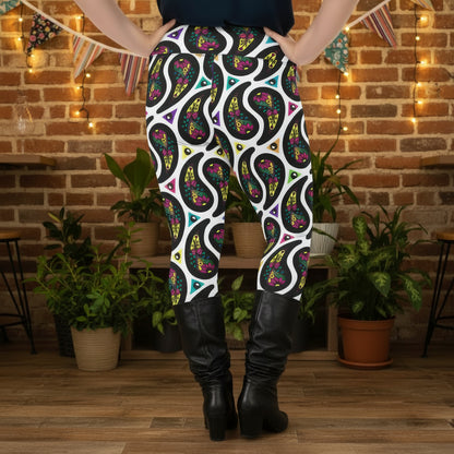 High waist Plus Size White Paisley Party festival yoga leggings back view. Woman is standing in a boho interior room.  The Paisley Party design is a bold colourful rainbow geometric print pattern. Designed in Wales, UK | Sassy Seagull. 