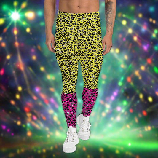 Man from the waist down wearing mens Yellow and Pink Leopard Glamour funky festival yoga leggings standing facing forwards with his hands by his sides. The man is wearing white trainers and surrounded by multicoloured string lights in a dark room that creates a colour explosion of light baubles. This design features an animal print pattern in black, grey and white, printed at a medium scale. The top 3/4 background is bright yellow with the bottom 1/4 bright pink