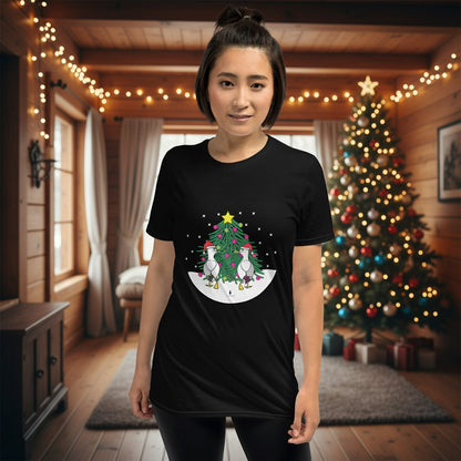 Person wearing a black 100% cotton Christmas t-shirt with two sassy seagulls in front of a decorated Christmas tree. The person is standing in a wooden chalet decorated for Christmas.