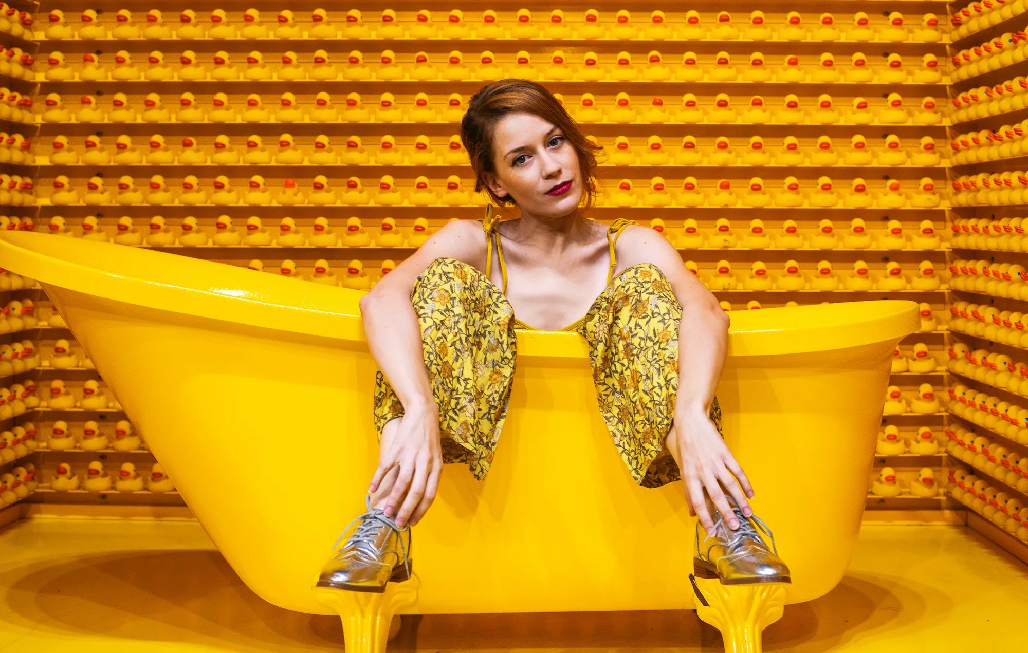 woman-sitting-in-a-yellow-bath-surrounded-by-yellow-rubber-ducks