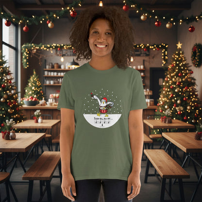Woman wearing a khaki green 100% cotton samba drumming seagulll in the snow Christmas t-shirt with the text Samba Baby in a rustic cafe filled with red, green and gold Christmas decorations