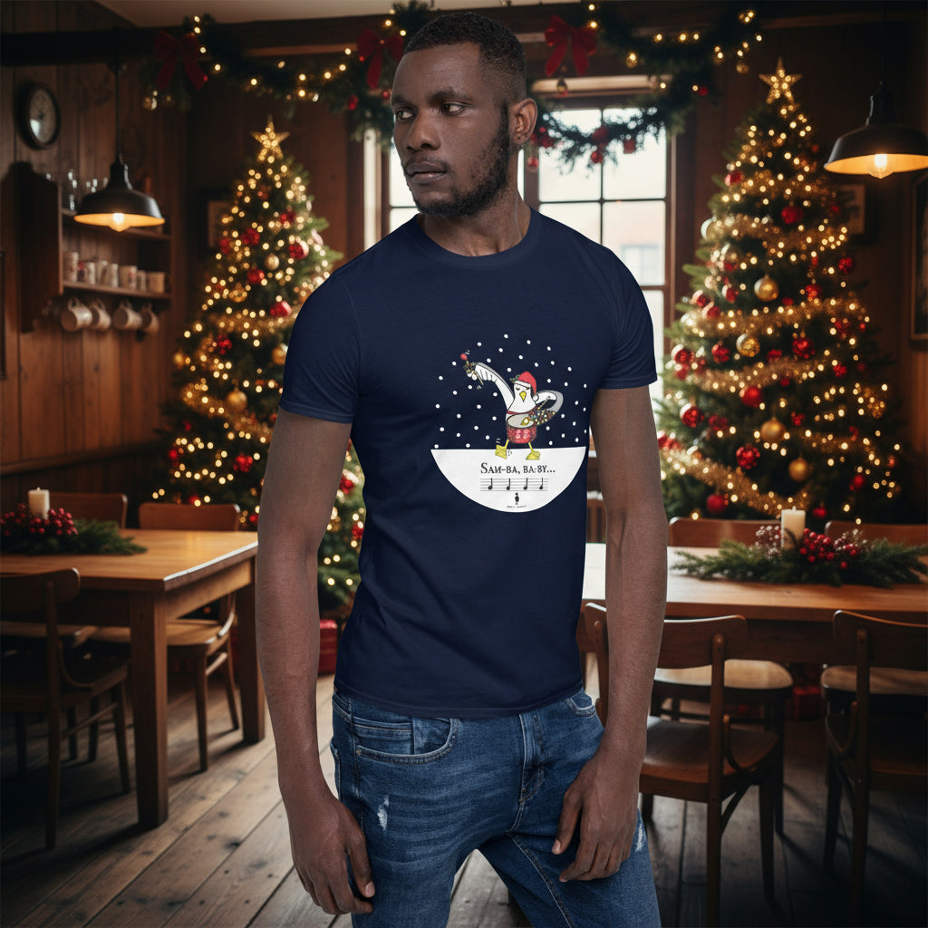 Man wearing a navy blue 100% cotton samba drumming seagulll in the snow Christmas t-shirt with the text Samba Baby in a rustic cafe filled with red, green and gold Christmas decorations