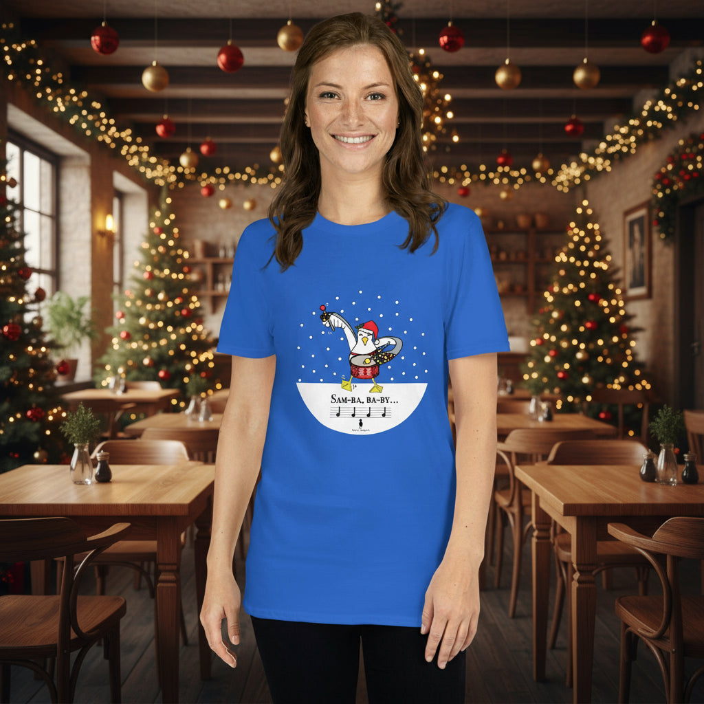 Woman wearing a royal blue 100% cotton samba drumming seagulll in the snow Christmas t-shirt with the text Samba Baby in a rustic cafe filled with red, green and gold Christmas decorations