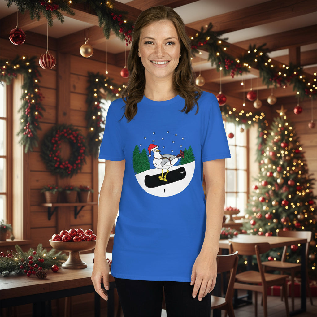 Woman wearing a royal blue 100% cotton snowboarding seagull Christmas t-shirt, in a rustic cafe filled with red, green and gold Christmas decorations