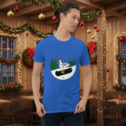 Man wearing a royal blue 100% cotton snowboarding seagull Christmas t-shirt, in a rustic cafe filled with red, green and gold Christmas decorations