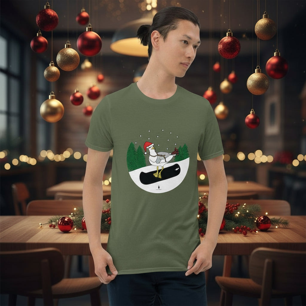 Man wearing a khaki green 100% cotton snowboarding seagull Christmas t-shirt, in a rustic cafe filled with red, green and gold Christmas decorations