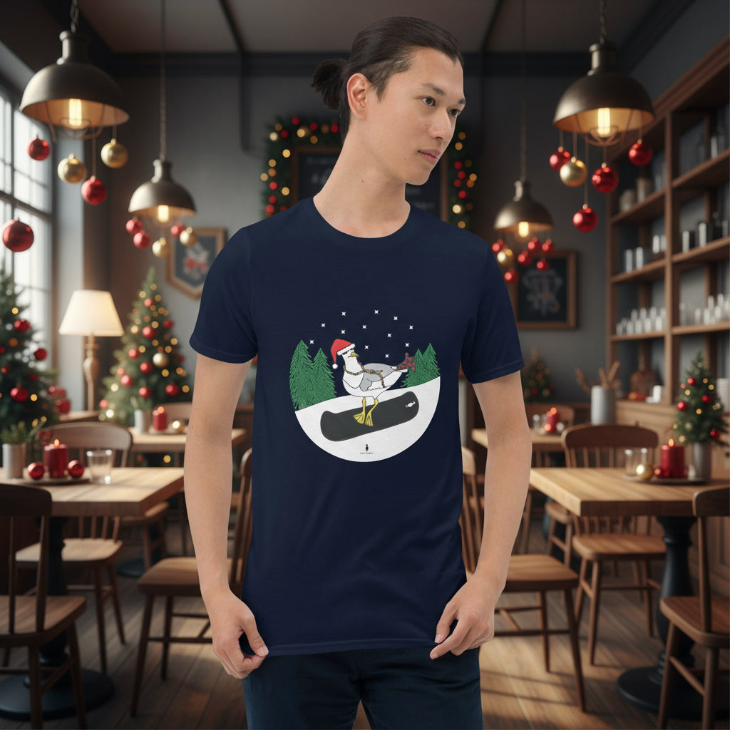 Man wearing a navy blue 100% cotton snowboarding seagull Christmas t-shirt, in a rustic cafe filled with red, green and gold Christmas decorations