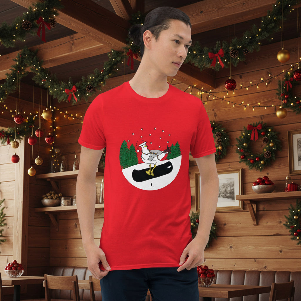 Man wearing a red 100% cotton snowboarding seagull Christmas t-shirt, in a rustic cafe filled with red, green and gold Christmas decorations