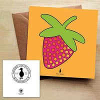 Card with a colourful and bold strawberry print on an orange background, with a brown envelope on a wooden table